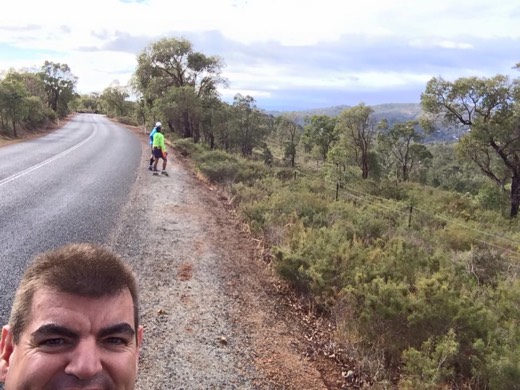 Gary taking a selfie with two walkers on the Day 1 road behind him