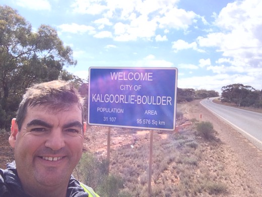 Gary smiling beside the Welcome City of Kalgoorlie-Boulder sign on Day 14