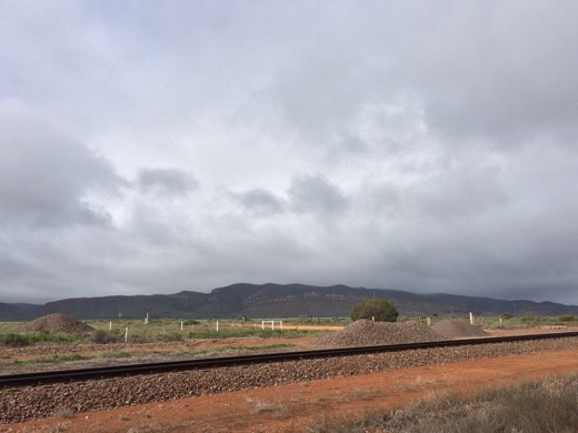 Railway line and hills under heavy grey cloud on Day 58