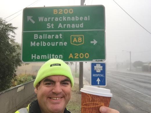 Gary in the yellow beanie beside a foggy Western Highway sign for Stawell, Ballarat and Melbourne