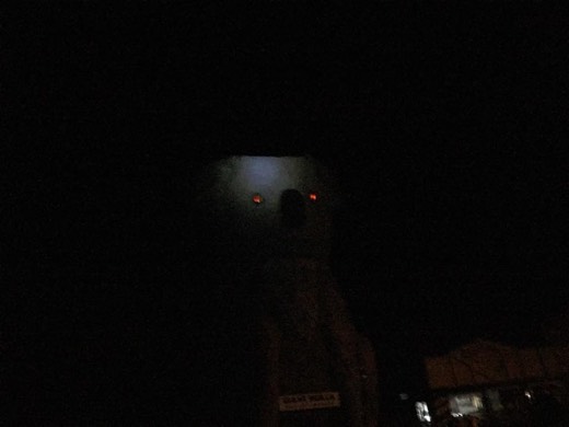 The Giant Koala at Dadswells Bridge barely visible in darkness, with two red-lit eyes above the sign.