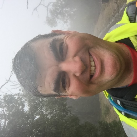 Gary smiling in wet hi-vis gear on a foggy Kinglake road during Day 83