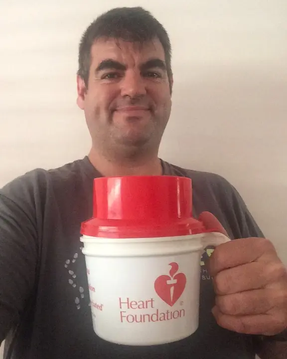 Gary holding a Heart Foundation fundraising collection bucket